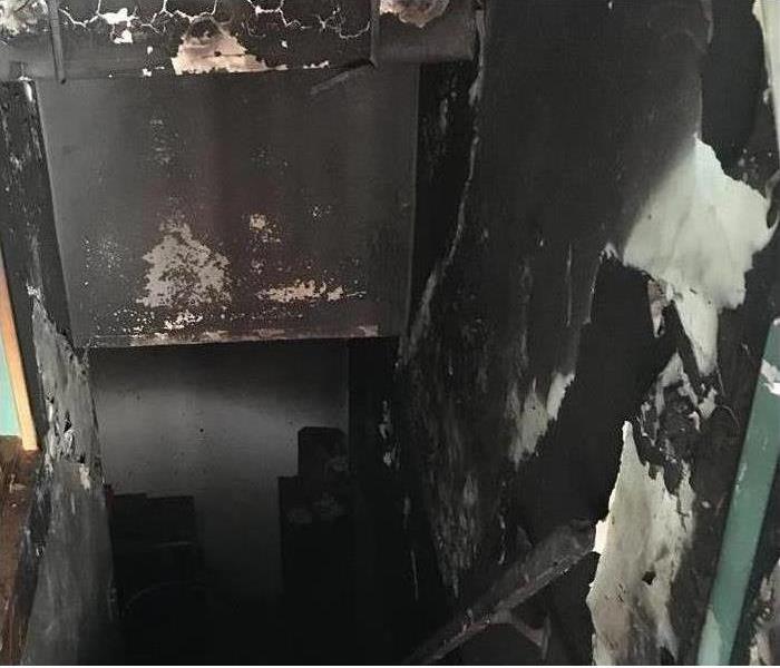 Image of a room and staircase damaged with soot and fire.